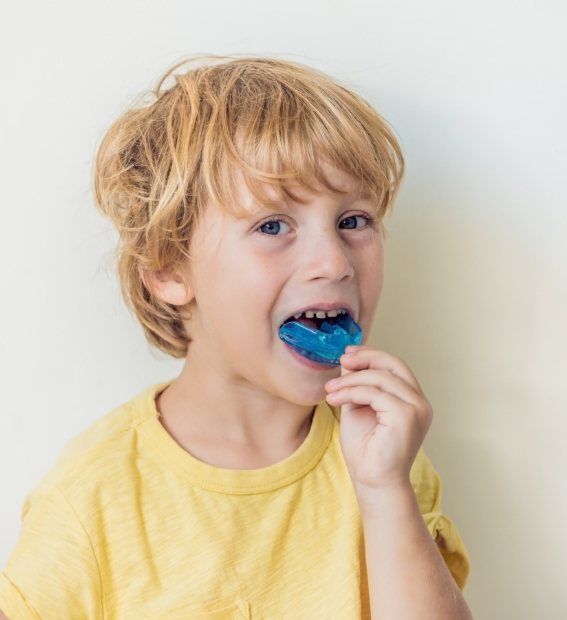 Child placing an athletic mouthguard