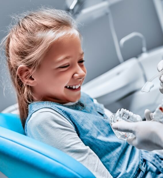 Dentist showing young patient smile model crafted using digital impression system