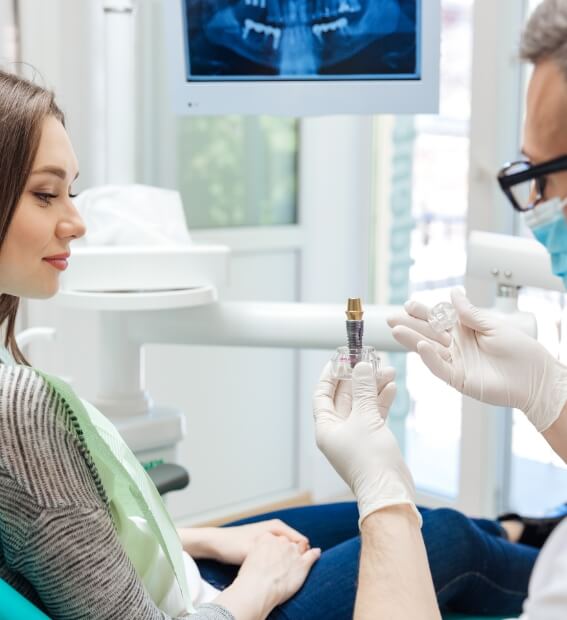 Dentist explaining the four step dental implant process